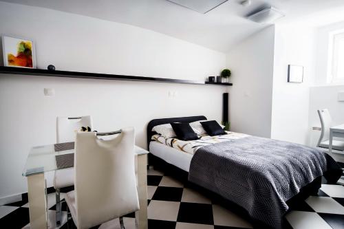 a bedroom with a bed and a checkered floor at Black and White Studio in Ljubljana