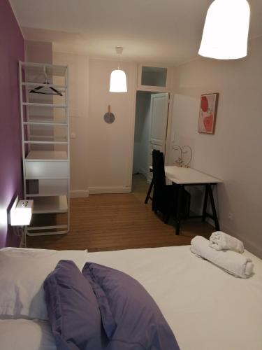 une chambre avec un lit, un bureau et une table dans l'établissement La Maison Saint-Pry, à Béthune