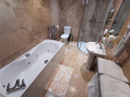un bagno con vasca, WC e lavandino di Rose in Vale Country House Hotel a St. Agnes 