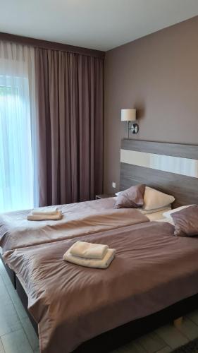 a bedroom with a large bed with two towels on it at Apartament Czarna Góra B11 in Sienna