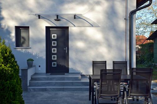 a table and chairs in front of a door at Fanni Vendégház in Dombóvár