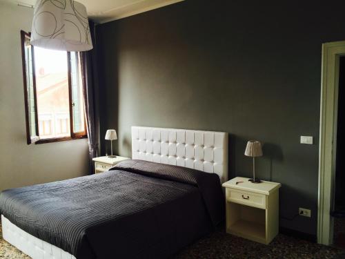 Un dormitorio con una cama grande y dos mesitas de noche. en Corte Loredana, en Venecia