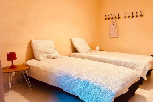 duas camas sentadas uma ao lado da outra num quarto em F3 - NEUF - 4/6 p - lits King size - Wifi - Cour em Le Puy-en-Velay