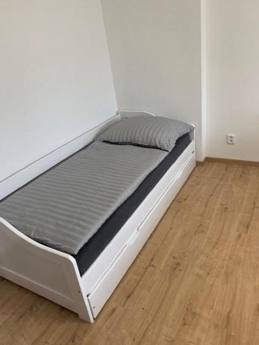 a bed in a room with a wooden floor at Apartmán Frymburk 30 in Frymburk