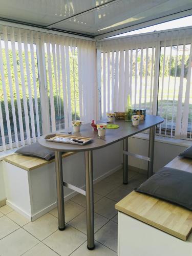 une salle à manger avec une table et une fenêtre dans l'établissement Le Tilburg, à Grandcamp-Maisy