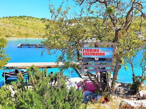 a sign for a fishing station next to a lake at Villa Spark with heated pool in Rogoznica Zecevo in Zečevo Rogozničko