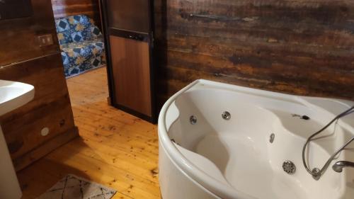 a white bath tub in a bathroom with a sink at Etna Rural Cottage with Jacuzzi in Pedara