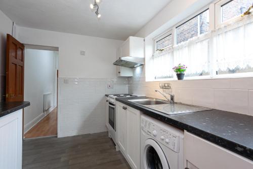 a white kitchen with a sink and a stove at 4 Bedroom House-City Centre- Free Parking-Sleeps 9 in Stoke on Trent