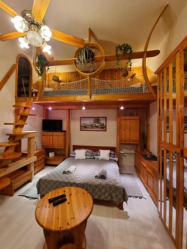 sypialnia z dużym łóżkiem i drewnianym sufitem w obiekcie Little Cozy Apartman w Miszkolcu