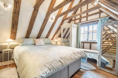 1 dormitorio con 1 cama en una habitación con techos de madera en Wonderful wooden beamed 17th century retreat - White Lion Cottage, en Hadleigh