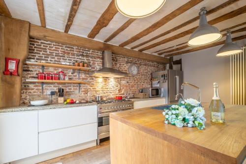 a kitchen with a counter and a brick wall at Wonderful wooden beamed 17th century retreat - White Lion Cottage in Hadleigh