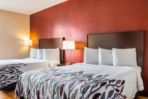 duas camas num quarto de hotel com paredes vermelhas em Red Roof Inn Dumas em Dumas