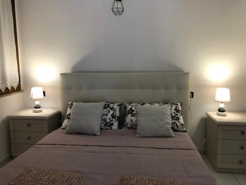 ein Schlafzimmer mit einem großen Bett mit zwei Nachttischen in der Unterkunft Elegante monolocale al centro del paese in Teulada