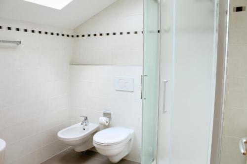 Un baño blanco con inodoro y lavabo. en byRosi Apartments, en Parcines