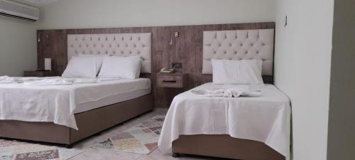 a bedroom with two beds with white linens at Hotel Villa Granada in Antalya