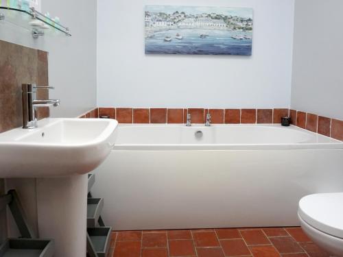 a bathroom with a white tub and a sink at Cornwallis House in Oxford