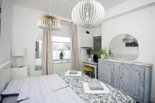 a bedroom with a bed and a desk and a mirror at Enjoy Ventnor 1, Pier Street, Wightlink offer in Ventnor