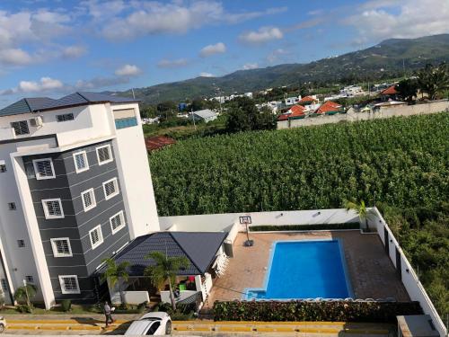 Blick auf ein Gebäude mit einem Pool und einem Weinberg in der Unterkunft My Beautiful Place in Santiago de los Caballeros