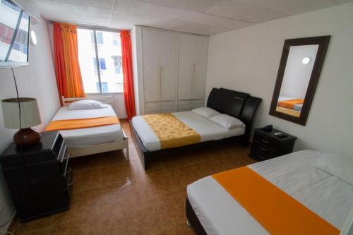 Habitación de hotel con 2 camas y espejo en Toscana Suite 10-18, en Cartagena de Indias