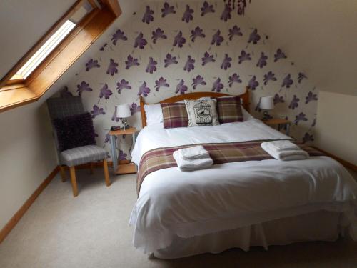 um quarto com uma cama com flores roxas na parede em 37 South Dell em Lower Shader