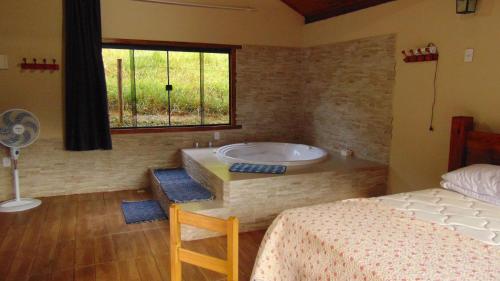 En eller flere senge i et værelse på Chalés com Hidromassagem e Lareira em Visconde de Mauá, Prox Pedra Selada, Pousada Leal Chalés