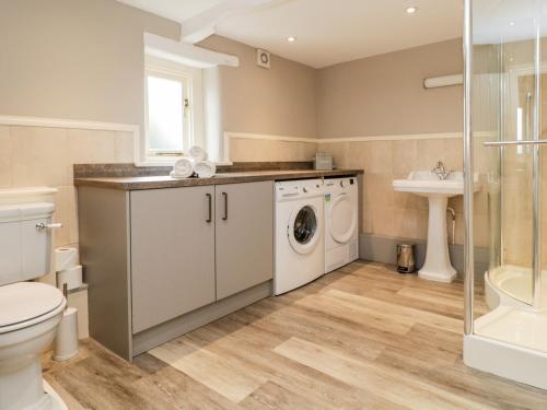 a bathroom with a washing machine and a sink at Otters Holt in Newby