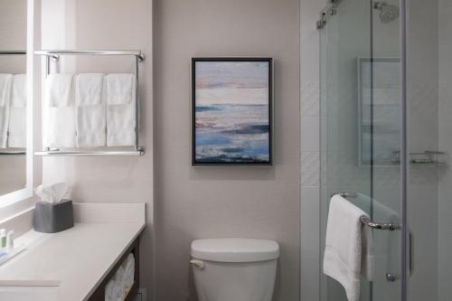a bathroom with a toilet and a glass shower at Holiday Inn & Suites Vancouver Downtown by IHG in Vancouver