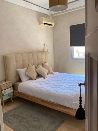 1 dormitorio con 1 cama grande con sábanas azules y ventana en Comme à la maison, en plein coeur de Marrakech, en Marrakech