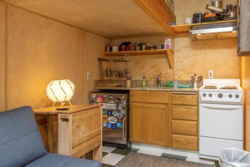 a small kitchen with a stove and a refrigerator at Alyeska North #400 in Girdwood