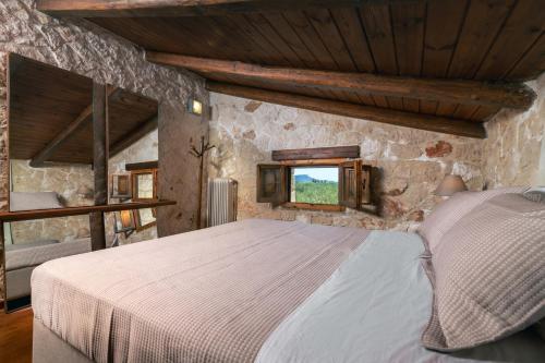 a bedroom with a bed in a stone wall at Villa Zeza in Kalipádhon