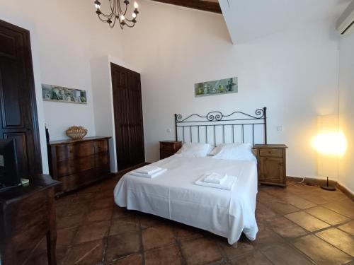 a bedroom with a large white bed with white sheets at Hotel Rural La Pedriza Original in Manzanares el Real