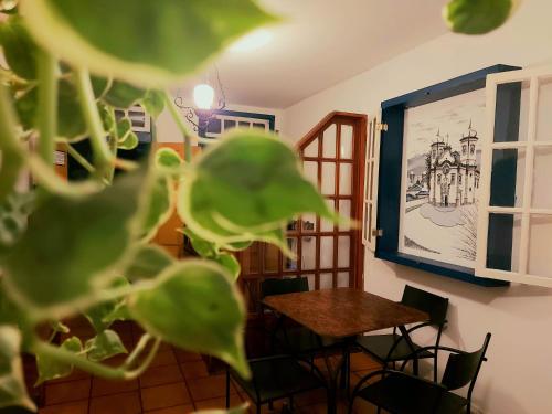 stół i krzesła w pokoju z rysunkiem na ścianie w obiekcie Pousada Janelas de Ouro Prêto w mieście Ouro Preto