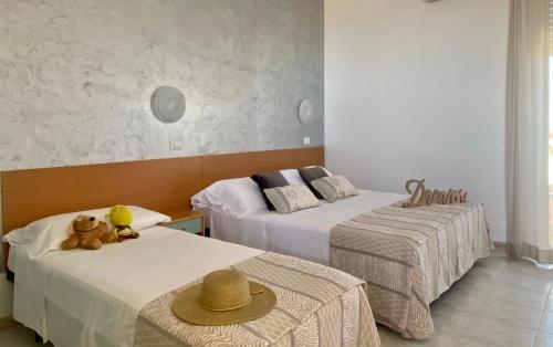 una stanza con due letti con sopra dei cappelli di Hotel Jumbo a Rimini