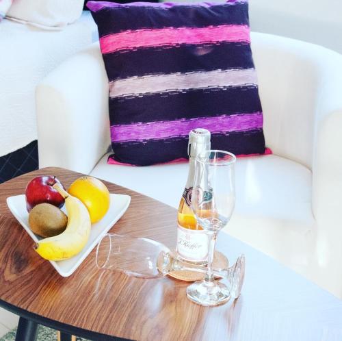 einen Tisch mit einer Glasflasche und einem Obstteller in der Unterkunft VIP Caribbean Views 300 meters to the Coral Estate beach in Willibrordus