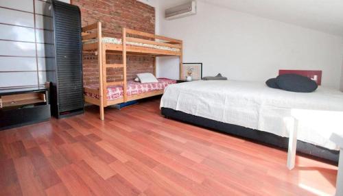 a bedroom with two beds and a wooden floor at Villa Gioia in Acqui Terme