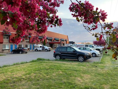 a parking lot with cars parked in front of a building at Hotel Transit in Mont-Saint-Hilaire