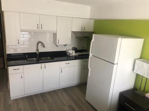 a kitchen with white cabinets and a white refrigerator at wallaceburg inn in Wallaceburg