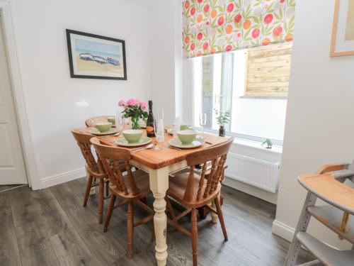 a dining room with a wooden table and chairs at The Robins in Filey