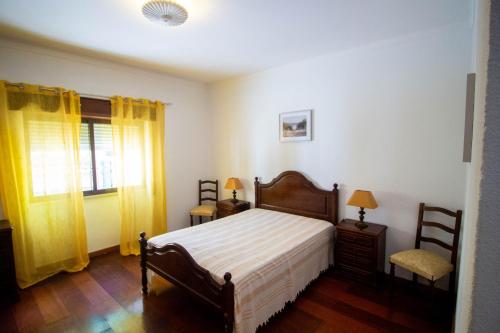 1 dormitorio con 1 cama, 1 silla y 1 ventana en Casa da Serra, en Quinta do Anjo