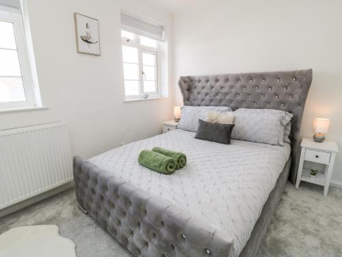 a bedroom with a large bed with a green towel on it at Martingale in Torquay