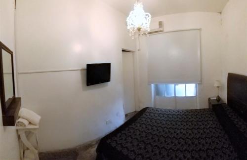 1 dormitorio con 1 cama y TV en la pared en 515 St. Patrick Guesthouse Hotel en Buenos Aires