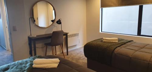 a bedroom with a bed and a mirror and a desk at Lakefront Apartments,18 LAKE ESPLANADE ROAD in Queenstown