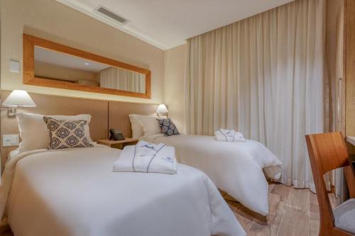 En eller flere senge i et værelse på Apartamento em Resort & Spa Gramado