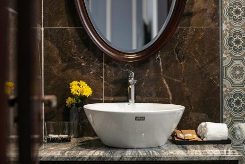 a bathroom with a white sink and a mirror at Romantique Hotel De Hanoi in Hanoi