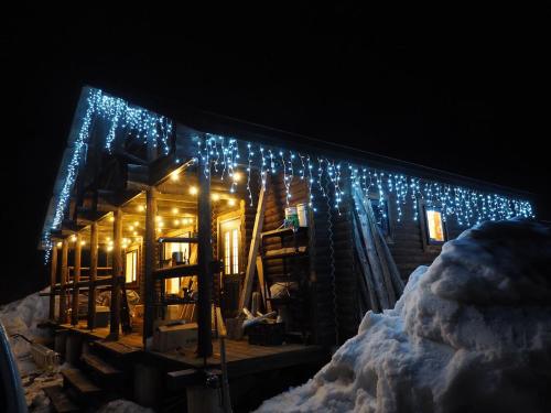 una cabaña de madera con luces de Navidad en ella en Minanonno Play Village, en Yoichi