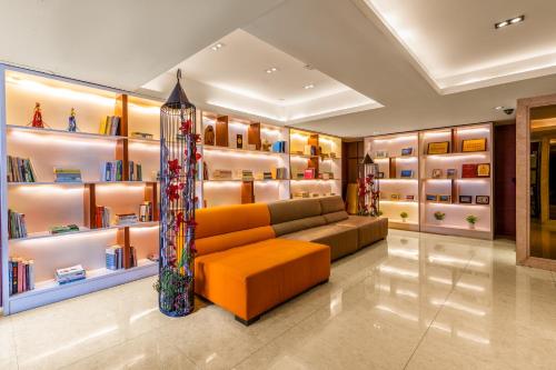 a living room with a couch and shelves of books at Foshan Poltton International Serviced Apartment in Foshan