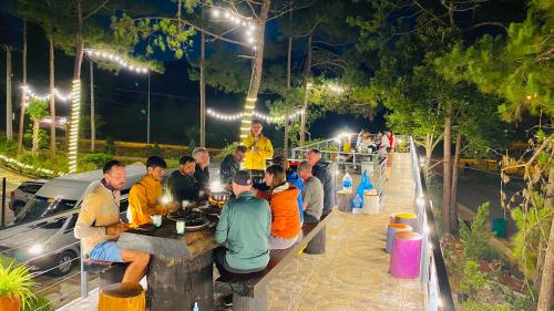 a group of people sitting at a table at night at HeniSi Homestay Măng Đen Villa in Kon Von Kla