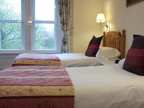 een hotelkamer met 2 bedden en een raam bij The Well House in Pitlochry