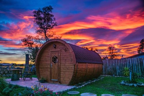 ein kleiner Schuppen mit Sonnenuntergang im Hintergrund in der Unterkunft Marlborough Wine Barrel Cabins in Blenheim