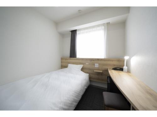 - une chambre avec un lit, un bureau et une fenêtre dans l'établissement R&B Hotel Nagoya Ekimae - Vacation STAY 15176v, à Nagoya